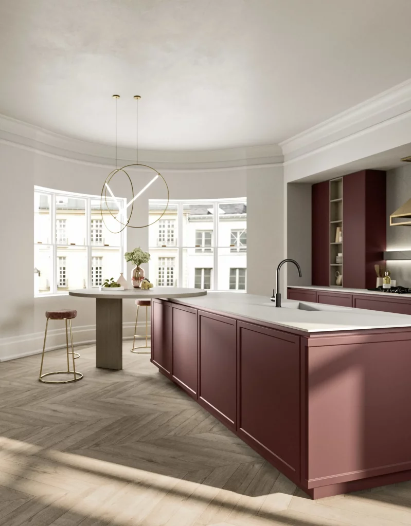 Modern kitchen with burgundy cabinets, white countertops, and a circular gold-ring pendant light by a curved bay window.